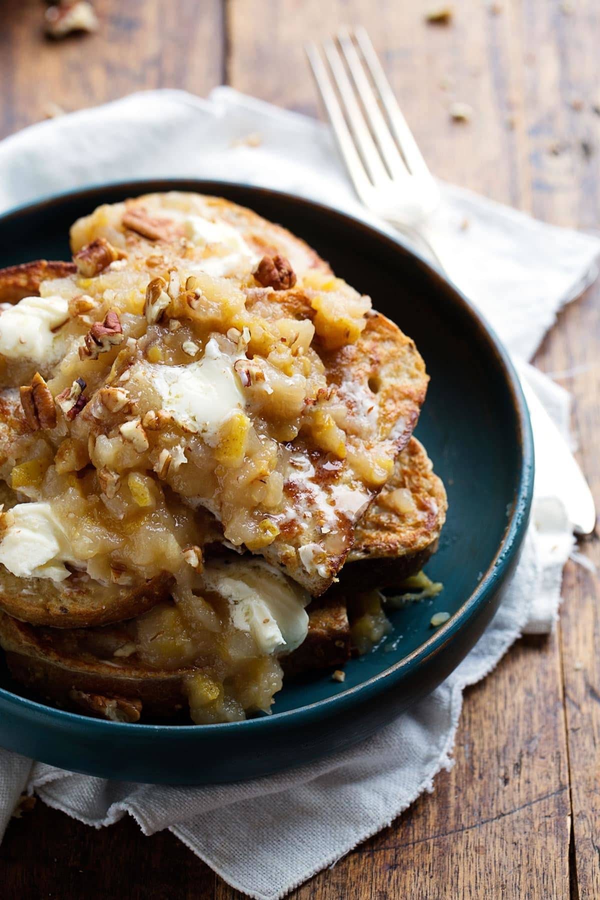 French Toast topped with Pear Chutney and Mascarpone on a dark plate.