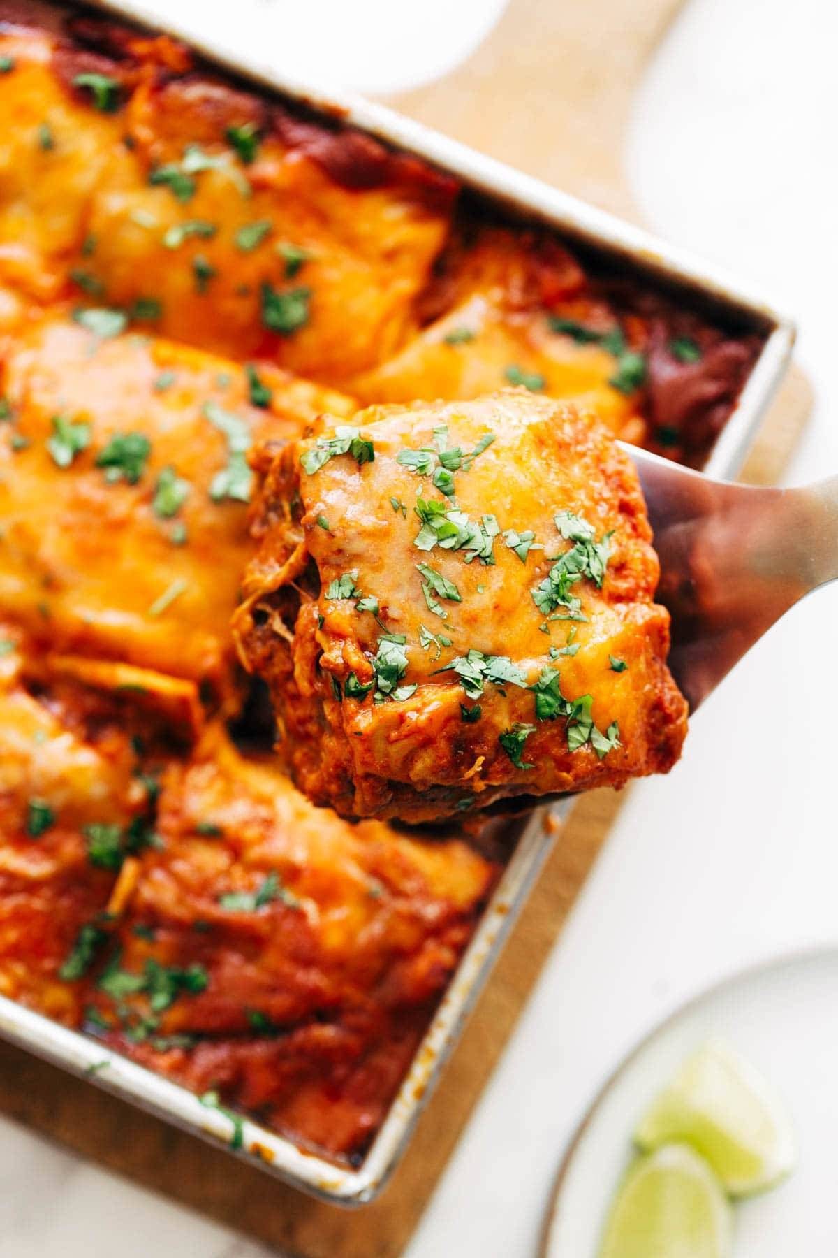 Taking a slice of enchilada casserole out of the pan.