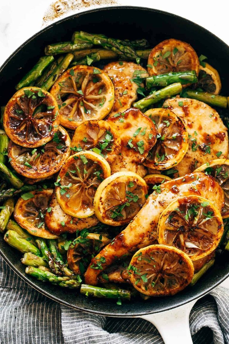 Lemon chicken and asparagus in a skillet.