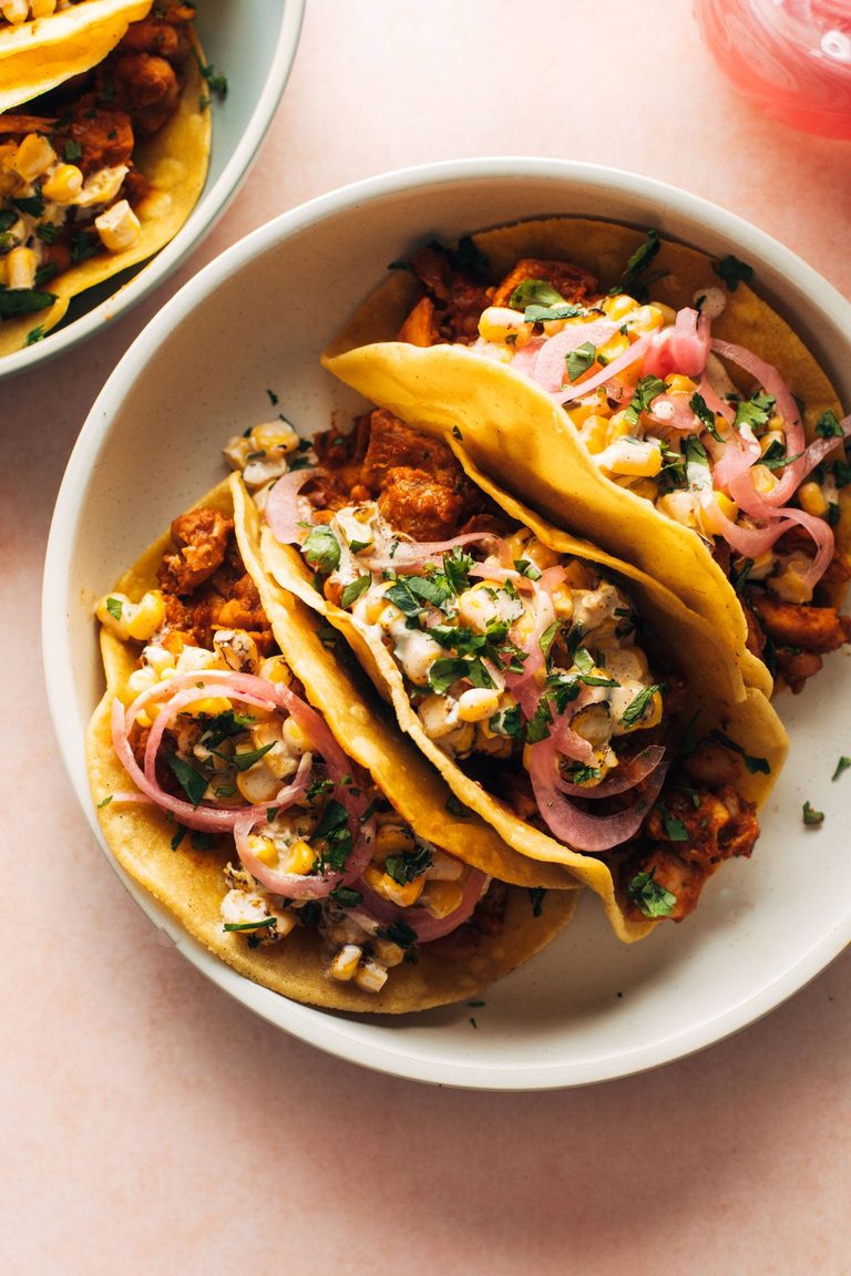 Chicken tacos with creamy corn on top.