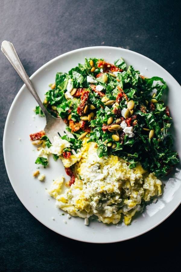Goat cheese scrambled eggs on a plate with a fork.